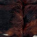 Closeup of this XS Tricolor Cowhide, showing long hair that is a mix of reddish brown and black, and a few white spots on the back (XS714)