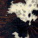 Closeup of this XS Tricolor Cowhide, showing a mix of black and brown, and one large and a few small, white spots that have back spots and speckles  (XS720)