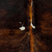 Closeup of this XS Brindle Cowhide, showing  black with brown, brindle markings, brown down the spine, and a few small, white spots (XS776)