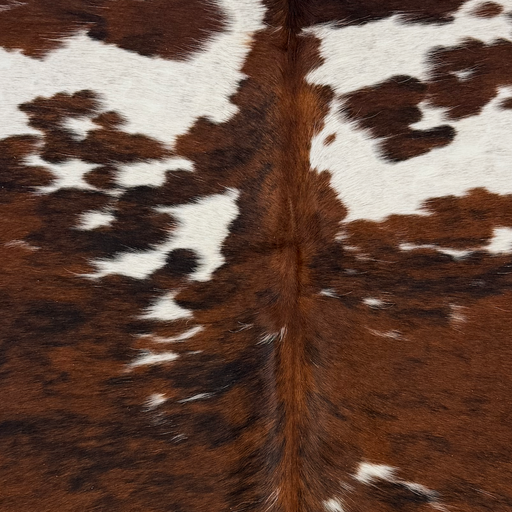Closeup of this XS Tricolor Cowhide, showing large and small spots with a reddish brown and black brindle pattern, and white spots with faint speckles  (XS790)