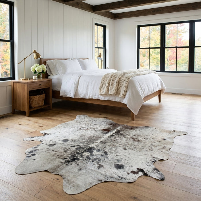 Salt and pepper Brazilian cowhide rug in a bright modern farmhouse bedroom with light oak floors
