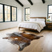 Brown salt and pepper Brazilian cowhide rug in a bright modern farmhouse bedroom with light oak floors