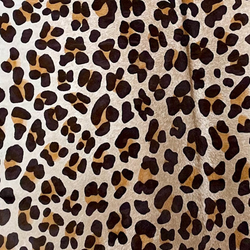 Closeup of this White and Light Brown, Brazilian Calf hide that has been stenciled with a brown and black, Leopard Print (BRCALFLP509)