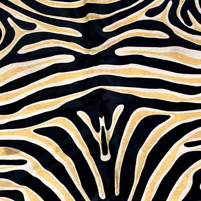 Closeup of this Brazilian Cowhide that is off-white, and has been stenciled with a black and yellow zebra print (BRZP026)