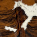 Closeup of this Colombian, Tricolor Cowhide, showing a brown and black, brindle pattern, a few white spots, and a strip of white with black, cloudy speckles across the right side of the shoulder (COTR733)
