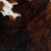 Closeup of this Dark Brindle, Mini Cowhide that is black and brown, and has a touch of white with black speckles, and brown and black spots, on the shoulder of the hide (MINI127)