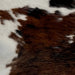 Closeup of this Tricolor Mini Cowhide, showing a brown and black, brindle pattern, with a few slashes of white, and off-white along some of the edges (MINI191)
